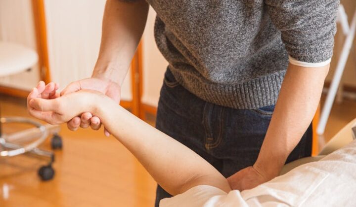 Chiropractor massaging hand of patient